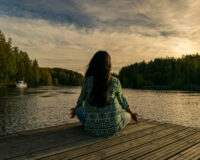 dziewczyna medytuje nad jeziorem, zachód słońca